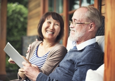 Senior couple on porch looking at tablet