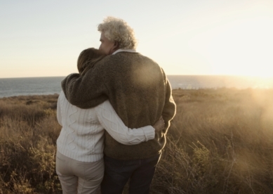 Couple Hugging in Field by Lake