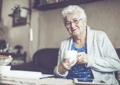 Senior woman on couch with coffee